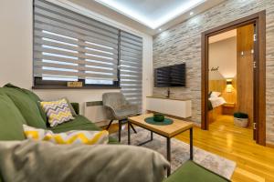 ein Wohnzimmer mit Sofa und Tisch in der Unterkunft Durmitor 64 - Titova vila in Zlatibor