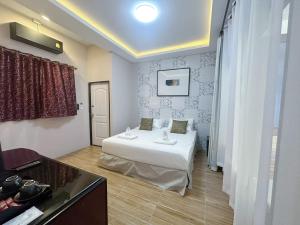 ein Hotelzimmer mit einem Bett in einem Zimmer in der Unterkunft Daddy Dream Hotel and Residence in Ranong
