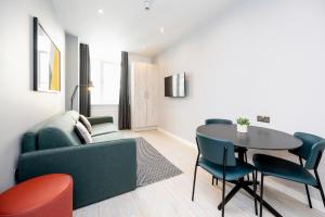 uma sala de estar com um sofá, uma mesa e cadeiras em Staycity Aparthotels Liverpool Waterfront em Liverpool