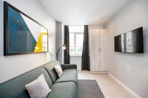 sala de estar con sofá verde y TV en Staycity Aparthotels Liverpool Waterfront, en Liverpool