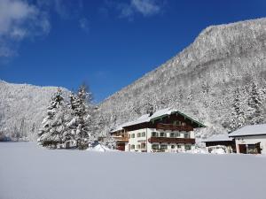 a building with snow on it in front of a mountain at Prümbachhof in Schneizlreuth