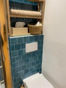 a blue tiled bathroom with a toilet and towels at Charme & authenticité AU COEUR de la vieille Ville in Antibes