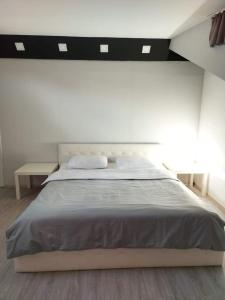 a white bedroom with a large bed and a table at Merter Apartments in Kavadarci