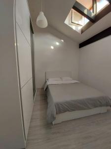 a white bedroom with a bed and a skylight at Merter Apartments in Kavadarci