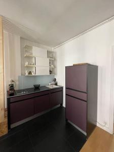 eine Küche mit einem lila Kühlschrank in einem Zimmer in der Unterkunft Appartement à côté de la plage avec balcon filant in Trouville-sur-Mer