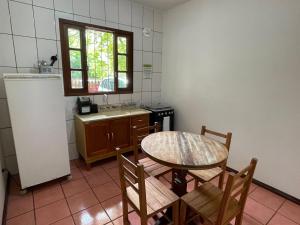una cucina con tavolo, sedie e lavandino di Nossa Guarda Acomodações a Guarda do Embaú
