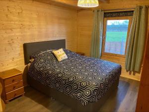 a bedroom with a bed and a window at Inviting 2-Bedroom Cabin in Ashton Under Hill in Evesham