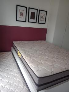 un colchón en un dormitorio con tres cuadros en la pared en PORTO DE GALINHAS- Muro Alto Condomínio Clube-B03, en Ipojuca