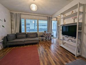 een woonkamer met een bank en een flatscreen-tv bij Ihana huoneisto meren lähellä. in Helsinki
