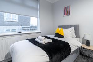 a bedroom with a large white bed with a window at Kirkview Apartment in Kirk of Shotts