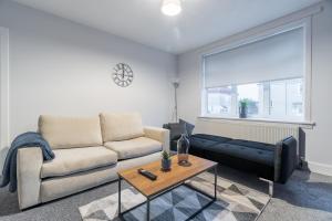 a living room with a couch and a table at Kirkview Apartment in Kirk of Shotts +25 photos