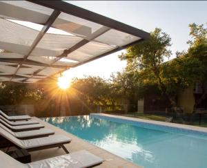 a swimming pool with lounge chairs and an umbrella at A Hotel Decosuites in Merlo