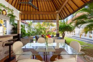 een eetkamer met een glazen tafel en stoelen bij Deby Villa Seminyak in Seminyak