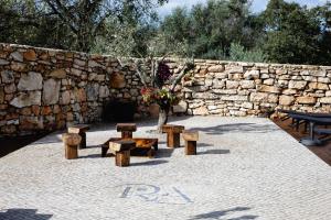 un grupo de bancos y un muro de piedra en Casa da Broa - Recantos d'Almerinda, en Alvito
