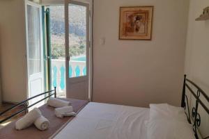 1 dormitorio con 1 cama con toallas y ventana en Villa Arginonta, en Kalymnos
