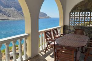 una mesa en un balcón con vistas al océano en Villa Arginonta, en Kalymnos