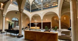 a large building with a lobby with chairs and tables at Hotel Mercer Sevilla 5 GL in Seville