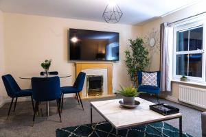 a living room with a table and a fireplace at Livingston North Station Apartments in Livingston