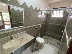 a bathroom with a sink and a toilet and a mirror at Nossa Guarda Acomodações in Guarda do Embaú +86 photos