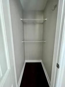 a small walk in closet with white walls and shelves at Modern 2-story apt w/ high speed Wi-Fi & Patio! in Charlotte