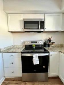 a kitchen with a black stove and a microwave at Modern 2-story apt w/ high speed Wi-Fi & Patio! in Charlotte
