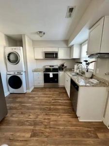 a kitchen with white appliances and a wooden floor at Gated 2BR Condo I 5 min Uptown in Charlotte