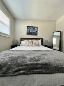 a bedroom with a large bed and a mirror at Modern 2-story apt w/ high speed Wi-Fi & Patio! in Charlotte