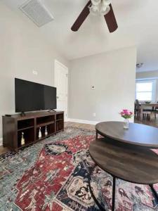 a living room with a flat screen tv and a table at Modern 2-story apt w/ high speed Wi-Fi & Patio! in Charlotte
