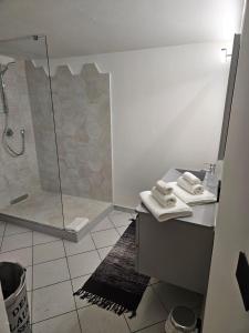 a bathroom with a shower and a sink with towels at REGINA Loft in Ospedaletti