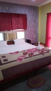 a bedroom with a large bed with pink flowers on it at Hotel Swagat in Puri