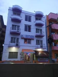 a white building with balconies on the side of it at Hotel Swagat in Puri
