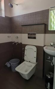 a bathroom with a toilet and a sink at Hobiz Serviced Apartments Chalakuzhy Nr Medical College Trivandrum in Trivandrum