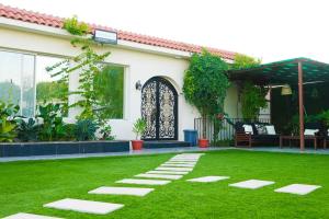 un jardin avec une passerelle en face d'une maison dans l'établissement شاليه ضفاف - Difaf Chalet - فخم وجديد وفاخر, à Djeddah