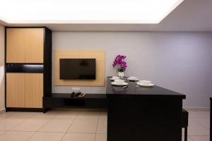 una camera con tavolo e TV a parete di Grand Ion Genting Highlands a Resorts World Genting