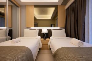 2 letti in una camera d'albergo con specchio di Grand Ion Genting Highlands a Resorts World Genting