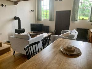 a living room with a table and chairs and a television at St Milburga Chapel 