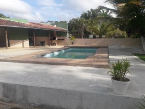 a swimming pool in front of a house at Casa temporada Condomínio fechado Praia de Barramares in Ilhéus