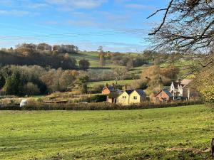 a green field with houses on a hill at St Milburga Chapel 