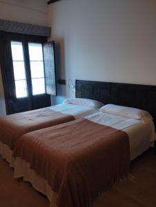 dos camas sentadas una al lado de la otra en un dormitorio en Posada Ignatius, en Navarrete