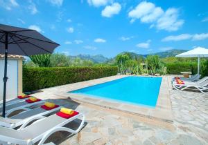 Villa con piscina con 2 tumbonas y sombrilla en Owl Booking Villa Alqueria Alt - Fantastic Mountain Views, en Campanet