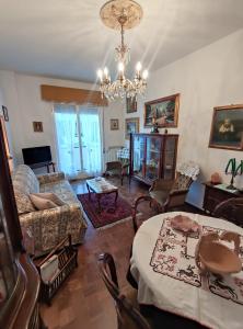- un salon avec un lustre, une table et des chaises dans l'établissement Casa Albina, à Rapallo