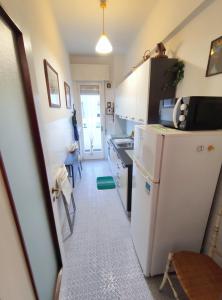 Elle comprend une petite cuisine équipée d'un réfrigérateur blanc et d'une table. dans l'établissement Casa Albina, à Rapallo