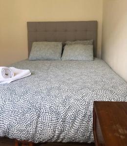 1 cama con edredón y almohadas en blanco y negro en Casa da Branca Gonta Colaço, en Lisboa