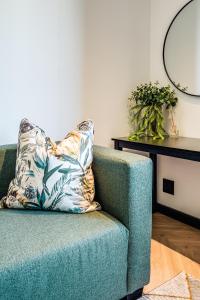 un sofá verde con una almohada en la sala de estar en Belina - Nine Palms Premier, en Ciudad del Cabo