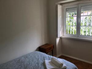 Schlafzimmer mit einem Bett und einem Fenster in der Unterkunft Casa da Branca Gonta Colaço in Lissabon