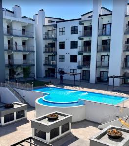 a swimming pool in front of a apartment building at Nivica 56 Luxury Apartment Langebaan in Langebaan