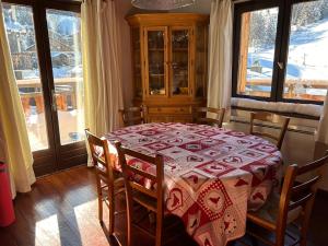 uma mesa de jantar com uma toalha de mesa vermelha e branca em Chalet au coeur de la plagne em Plagne 1800