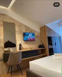a bedroom with a bed and a television on a wall at Hotel Comfort & Villas in Donji Štoj