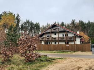 uma casa com uma cerca em frente em Dwór pod Sosnami Kaszuby em Ostrzyce