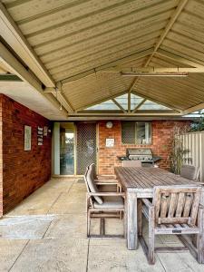 a wooden table and chairs on a patio at Family Home Close To All Perth Adventures in Hamilton Hill